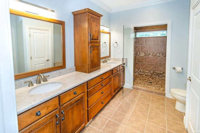 bathroom with toilet, tile patterned flooring, ornamental molding, vanity, and a tile shower