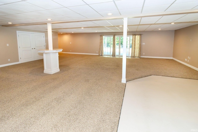 basement featuring light colored carpet and a drop ceiling