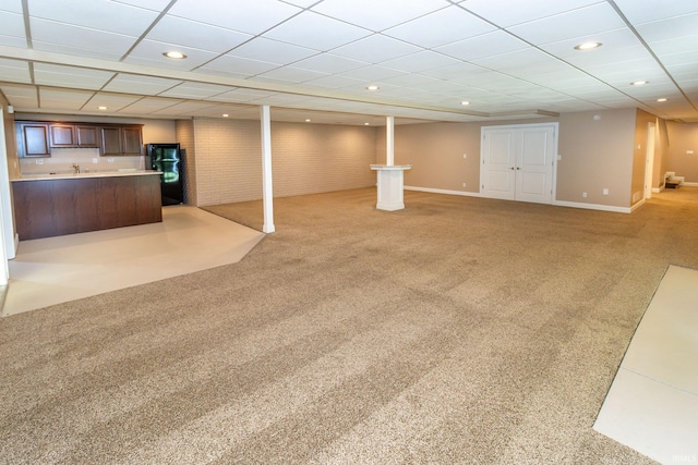 basement with light colored carpet and a drop ceiling