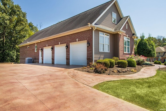 view of side of property featuring central air condition unit, a lawn, and a garage