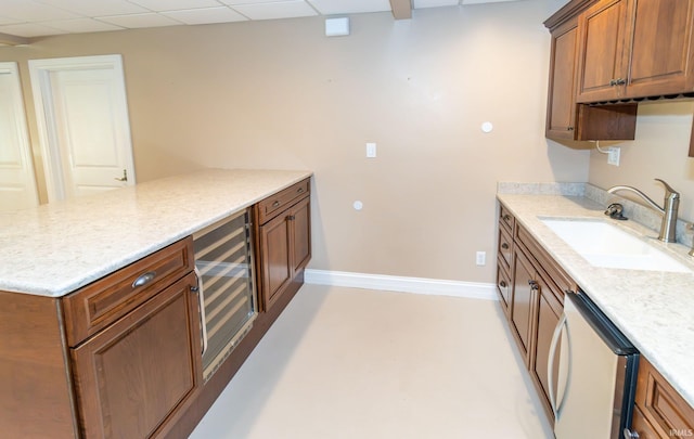 kitchen with a paneled ceiling, wine cooler, kitchen peninsula, sink, and stainless steel dishwasher