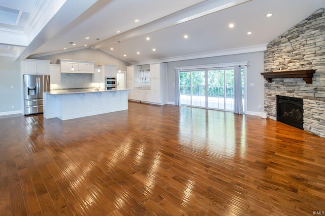 unfurnished living room featuring hardwood / wood-style flooring, a fireplace, crown molding, and lofted ceiling with beams