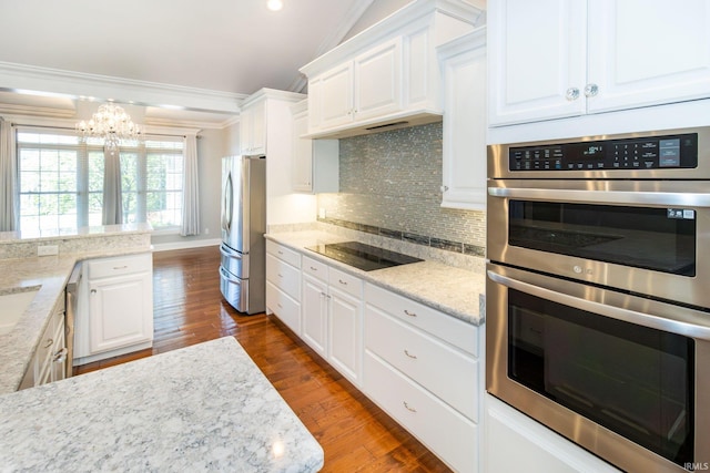 kitchen with dark hardwood / wood-style floors, stainless steel appliances, a chandelier, and white cabinetry