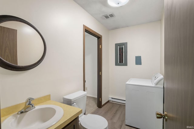 bathroom featuring toilet, vanity, a baseboard radiator, washer / dryer, and hardwood / wood-style flooring