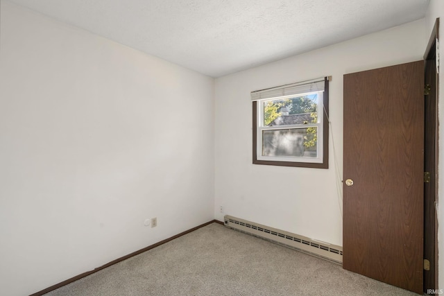 carpeted spare room with a textured ceiling and a baseboard radiator