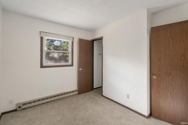 unfurnished bedroom featuring a baseboard radiator, light colored carpet, and a textured ceiling