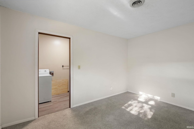 unfurnished room with washer / dryer and carpet