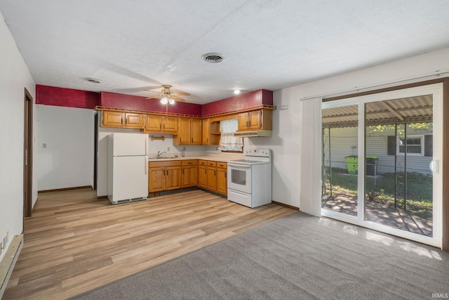 kitchen featuring white appliances, light hardwood / wood-style flooring, sink, a baseboard radiator, and ceiling fan