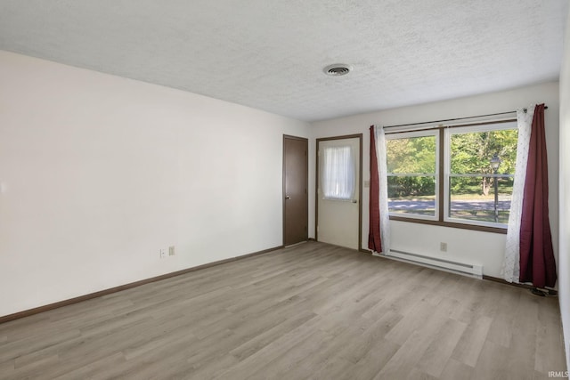 spare room with a textured ceiling, light hardwood / wood-style flooring, and baseboard heating