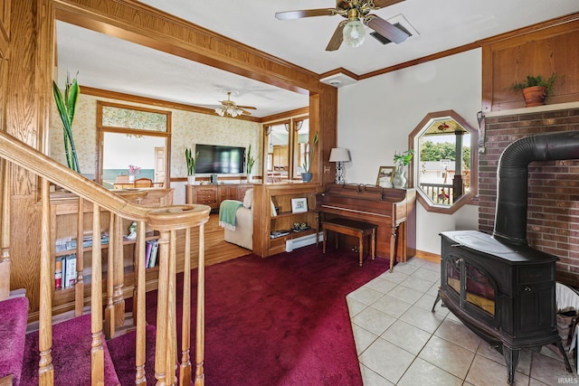 carpeted living room featuring crown molding, baseboard heating, ceiling fan, and a wood stove