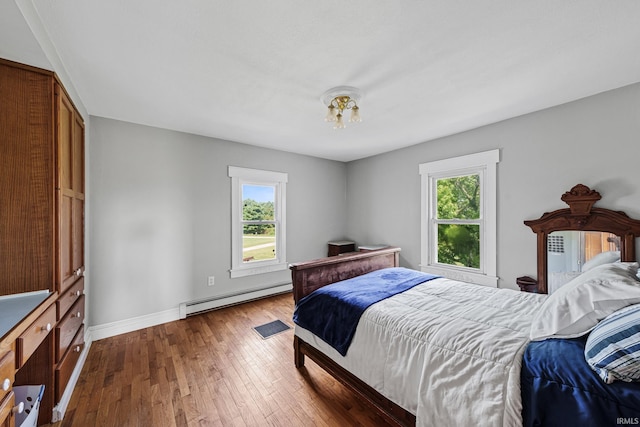 bedroom with baseboard heating and dark hardwood / wood-style flooring