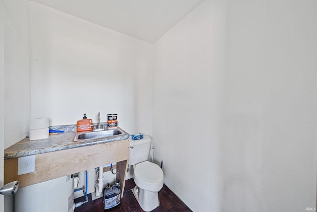 bathroom featuring wood-type flooring, toilet, vaulted ceiling, and sink