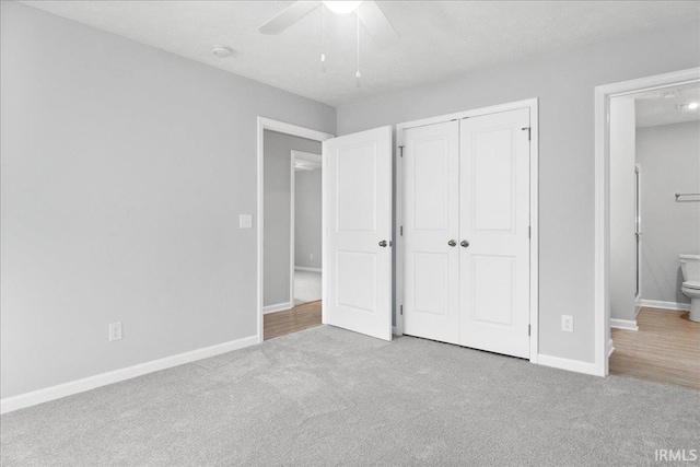 unfurnished bedroom with ensuite bath, light wood-type flooring, a closet, ceiling fan, and a textured ceiling