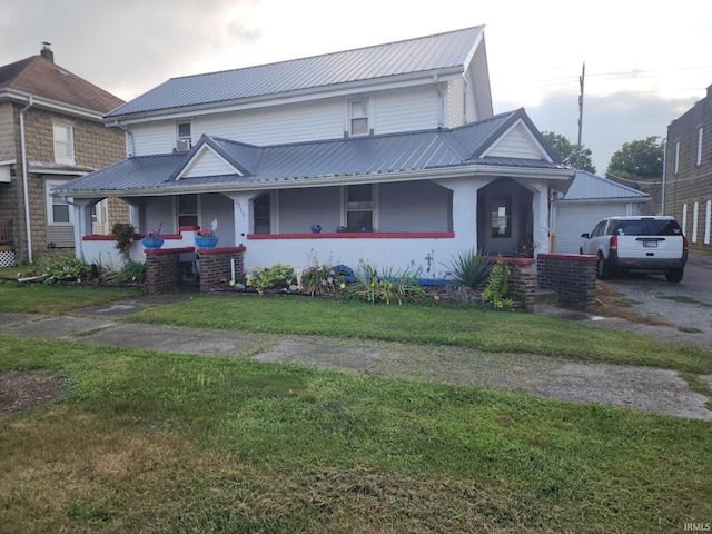 view of front facade featuring a garage, covered porch, and a front yard