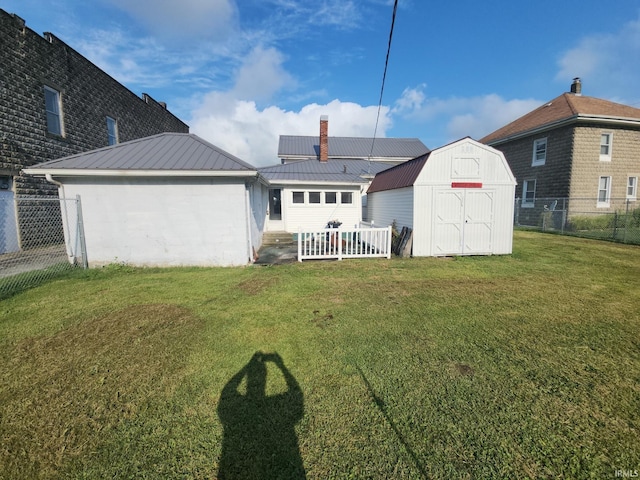 back of house featuring a storage shed and a lawn