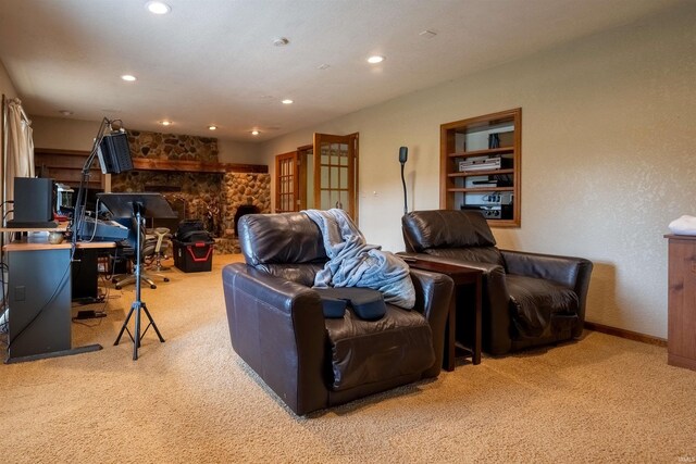 carpeted living room with a stone fireplace