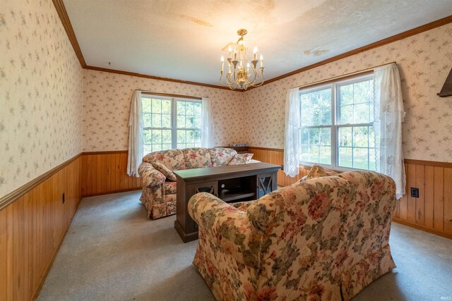 living room featuring carpet floors, a chandelier, crown molding, and a textured ceiling