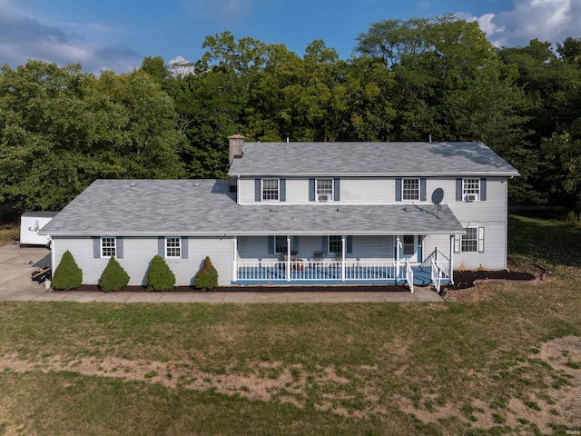 colonial home with a front lawn, a patio, and a swimming pool