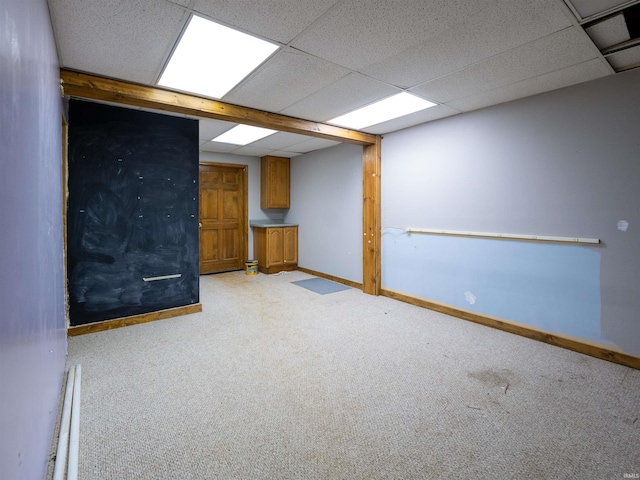 carpeted empty room with a drop ceiling