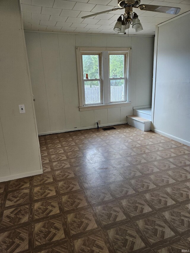 spare room featuring ceiling fan and parquet flooring