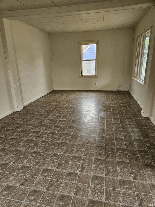 empty room with plenty of natural light and a drop ceiling