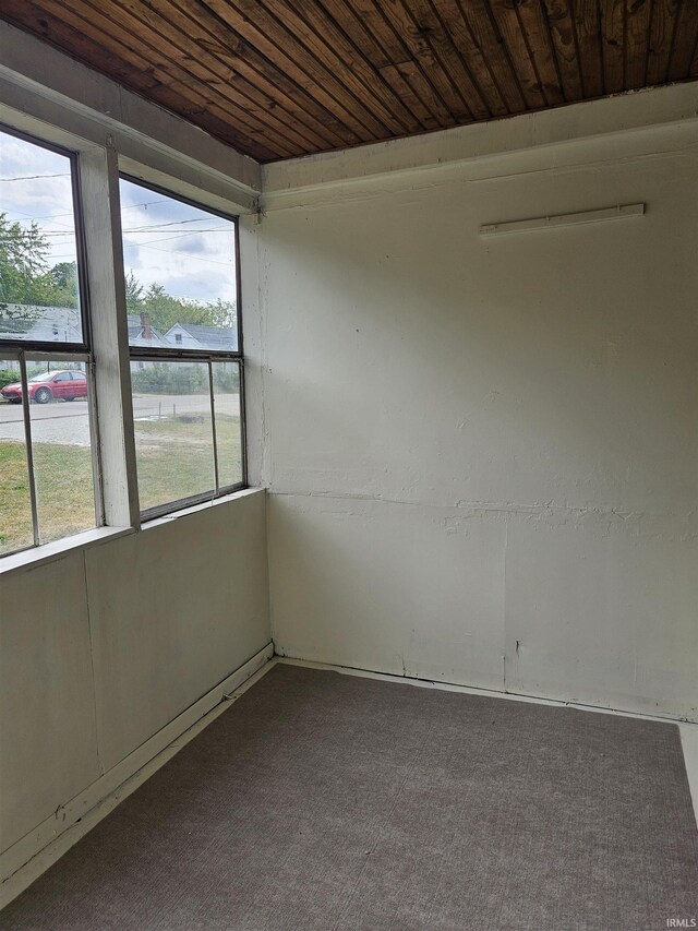 carpeted empty room featuring wooden ceiling