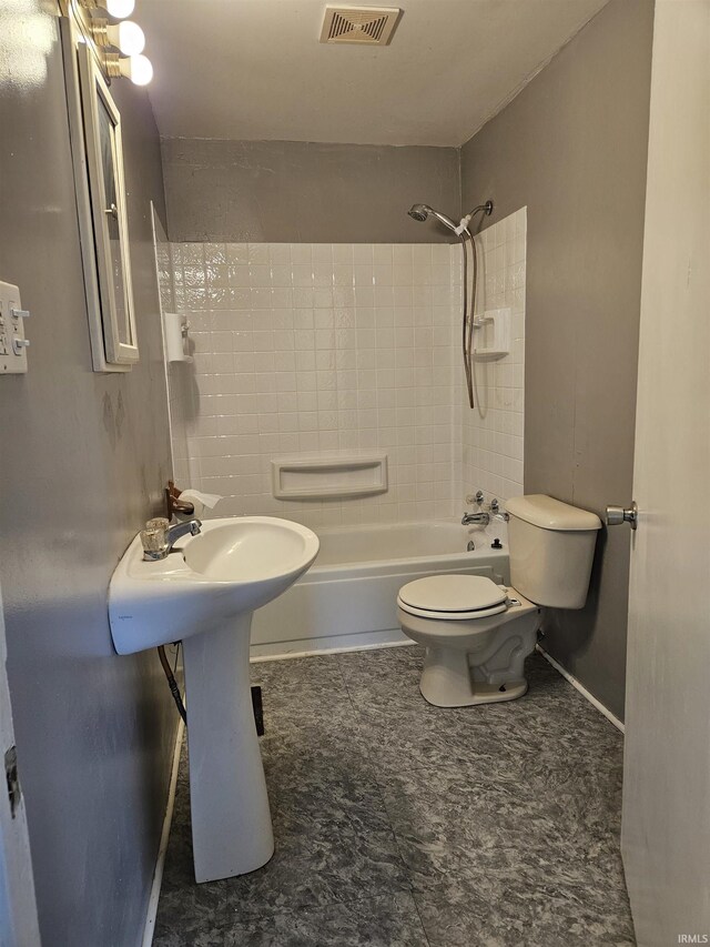 bathroom featuring tiled shower / bath and toilet