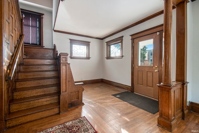 foyer entrance with plenty of natural light, ornamental molding, and wood-type flooring