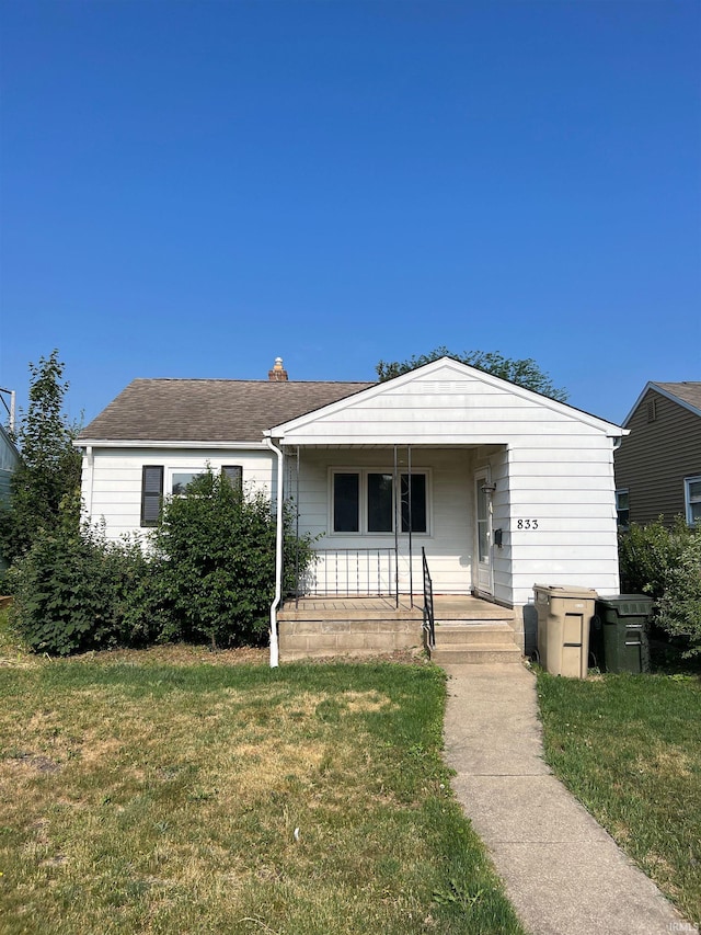 view of front of house featuring covered porch and a front yard