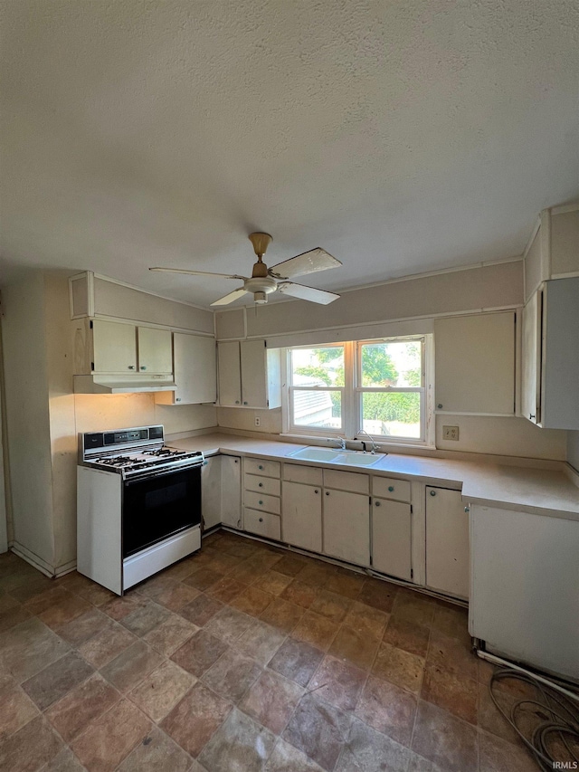 kitchen with white range with gas stovetop, ceiling fan, sink, and a textured ceiling