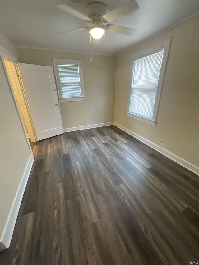 empty room with ceiling fan and dark hardwood / wood-style flooring