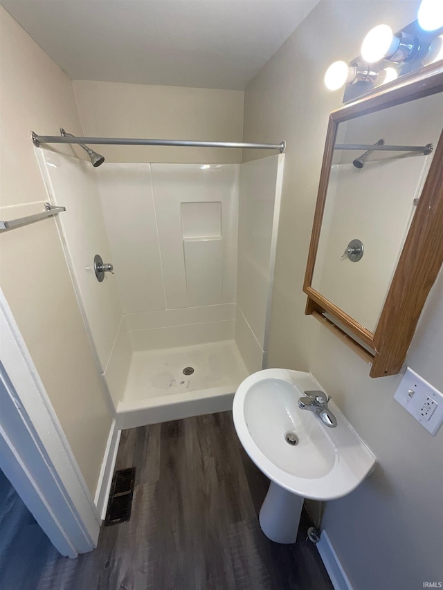 bathroom with walk in shower and wood-type flooring