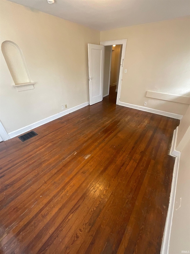 empty room with dark hardwood / wood-style flooring