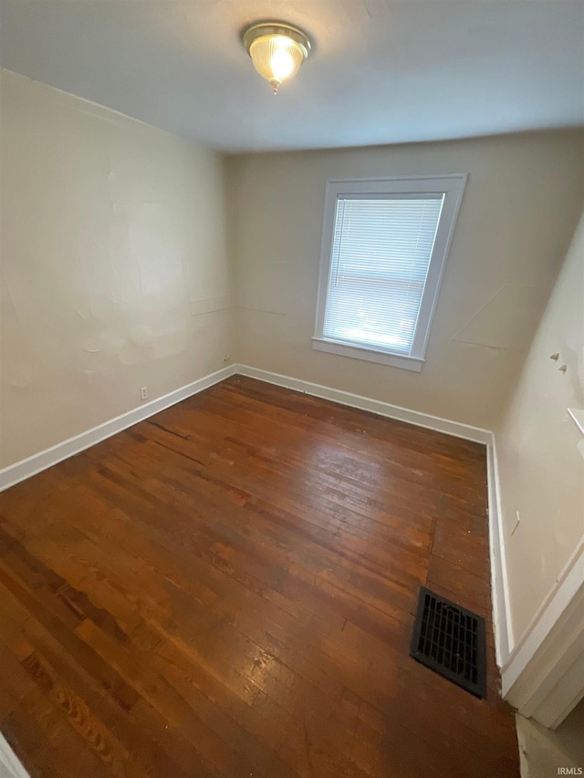 empty room with dark hardwood / wood-style flooring