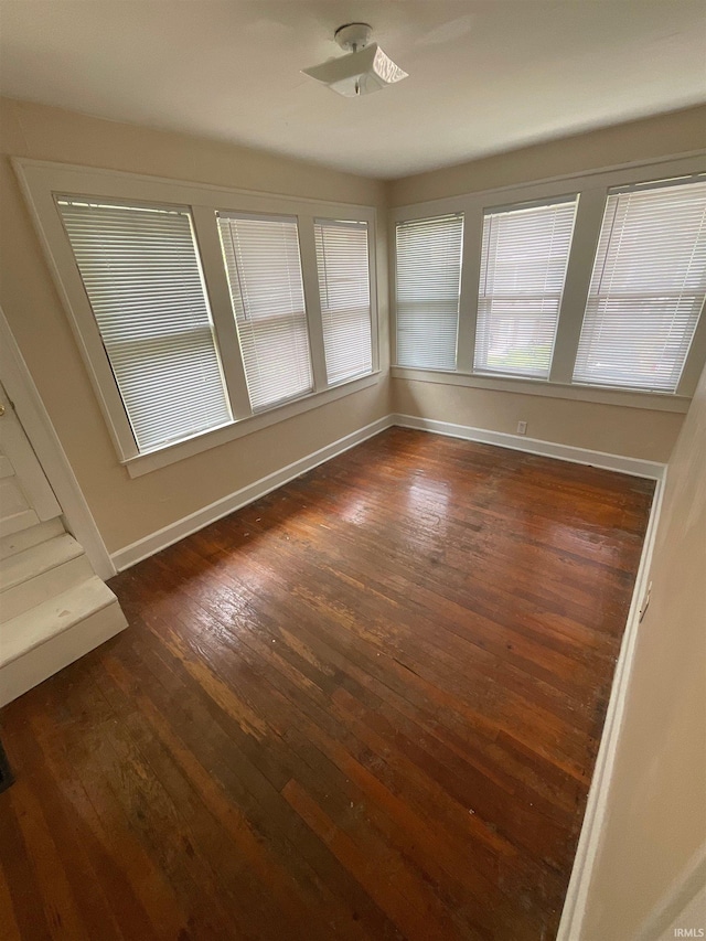 spare room featuring dark wood-type flooring and ceiling fan