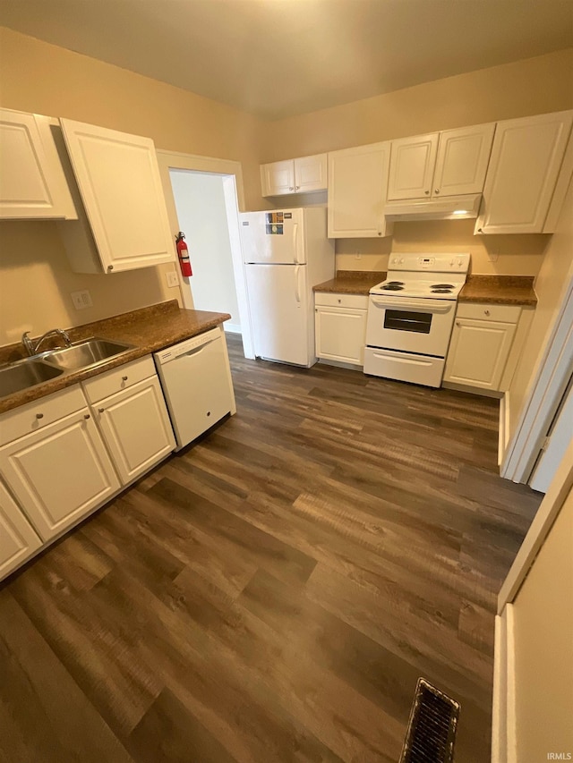 kitchen with white appliances, dark hardwood / wood-style flooring, sink, and white cabinets