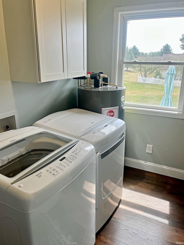 washroom with dark wood-type flooring, cabinets, water heater, and washing machine and dryer