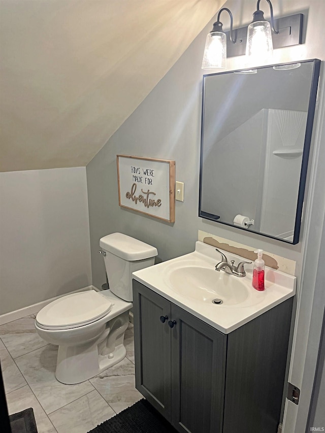 bathroom with vanity, toilet, and lofted ceiling