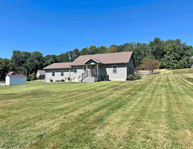 rear view of house with a yard and a shed