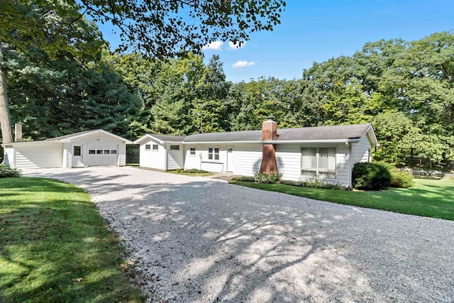 ranch-style house featuring an outbuilding, a garage, and a front lawn