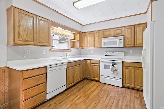 kitchen with crown molding, white appliances, sink, and light hardwood / wood-style floors