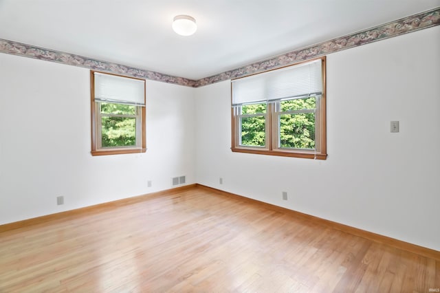 unfurnished room featuring light hardwood / wood-style flooring and a healthy amount of sunlight