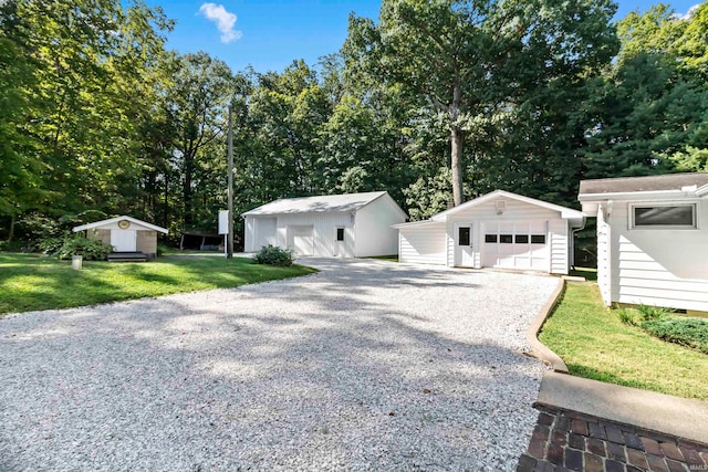 view of front of home featuring a storage unit, a garage, and a front yard