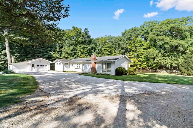 ranch-style home featuring an outbuilding, a garage, and a front lawn