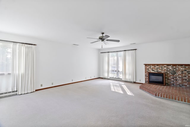 unfurnished living room featuring ceiling fan, light colored carpet, and a fireplace