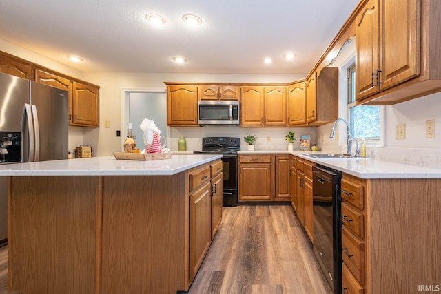 kitchen featuring dark hardwood / wood-style floors, black appliances, sink, and a center island