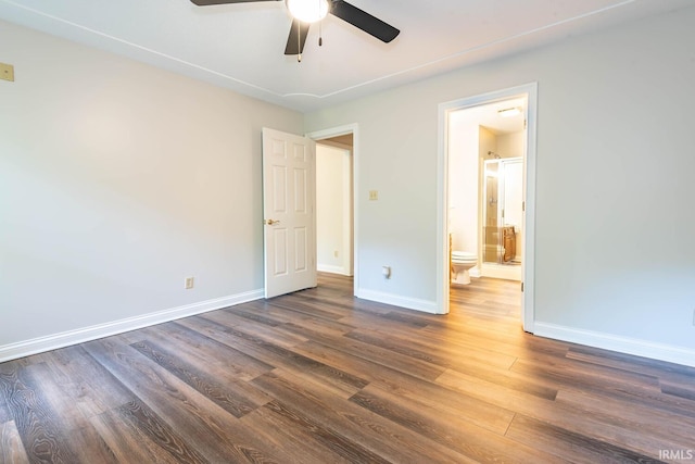 unfurnished bedroom featuring dark wood-type flooring, ceiling fan, and connected bathroom