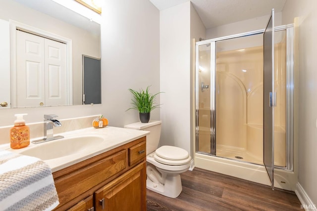 bathroom featuring vanity, toilet, hardwood / wood-style flooring, and walk in shower