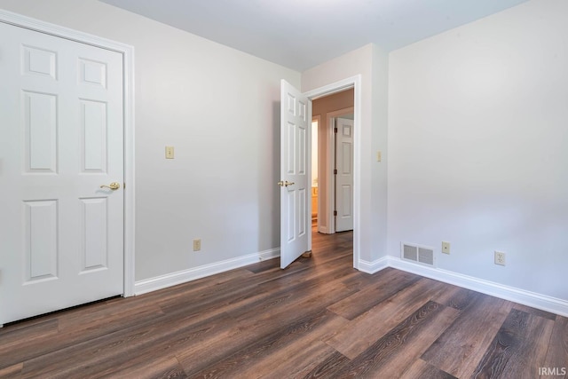 unfurnished bedroom with dark hardwood / wood-style flooring