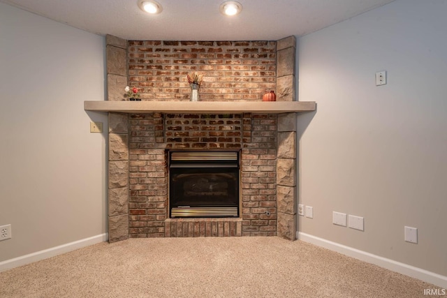 room details featuring a textured ceiling, carpet floors, and a fireplace